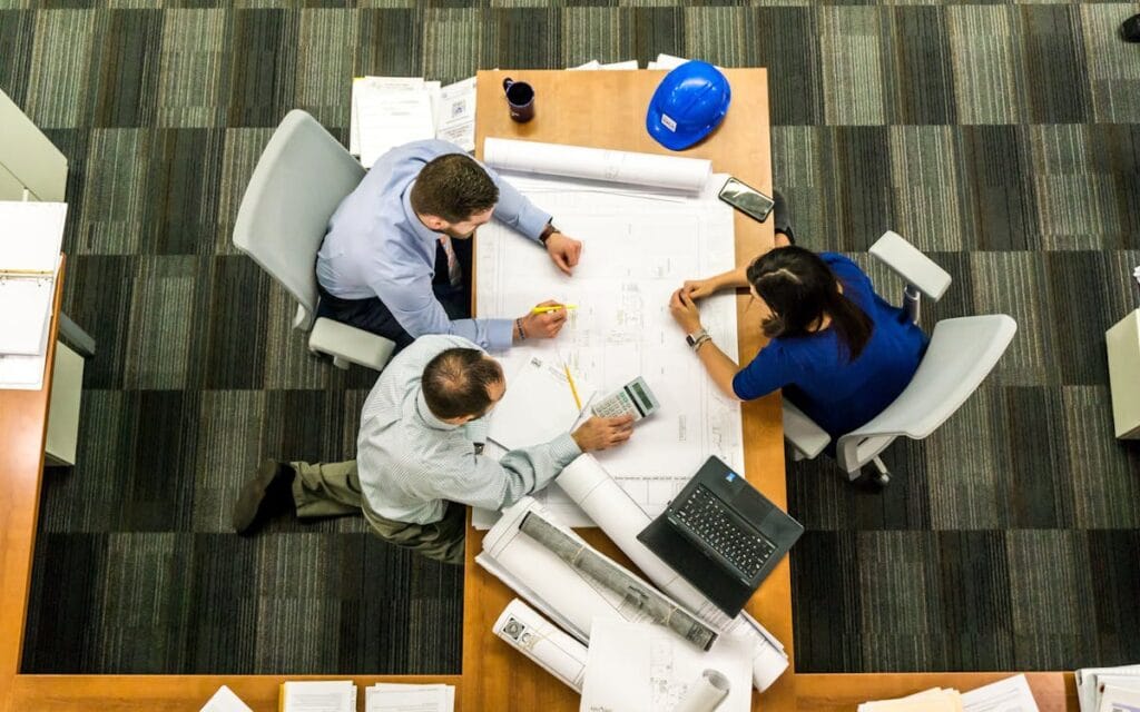 Three professionals discussing construction financing.